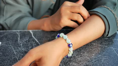 mujer con una pulsera de cuentas en la muñeca