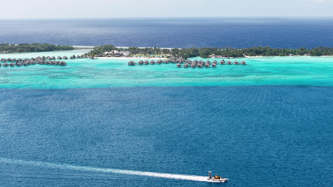 Ripresa con drone della laguna dell'isola di Bora Bora, bungalow di un resort di lusso e una barca
