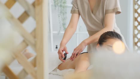 woman receiving a stone massage at a spa