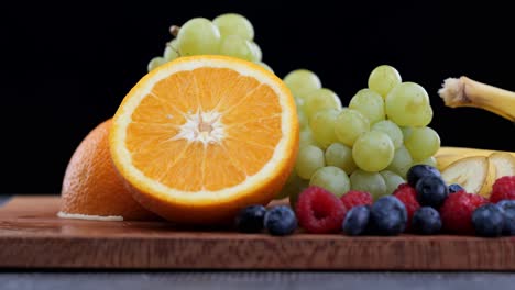 Fresh-fruit-on-wooden-cutting-board,-pan