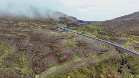 Car-Driving-Up-The-Mountain-Pass-In-East-Iceland---aerial-drone-shot