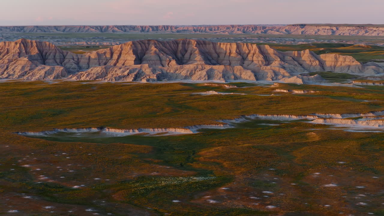 Sunset Glow Illuminating Harsh Badlands Ridges in Aerial Flight