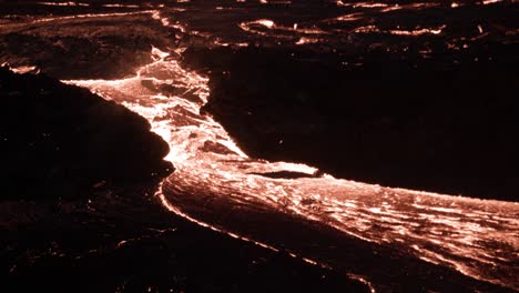 río de lava viscosa caliente que fluye en la superficie de la tierra por la noche, islandia
