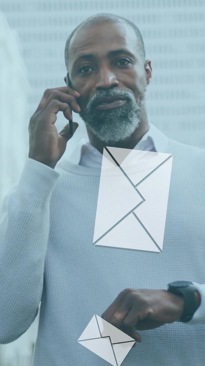 Animation of digital mail envelope icons over african american man using smartphone in city