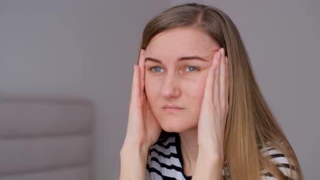 a woman feels a headache rubbing her temples with her hands a woman feels a headache rubbing her temples with her hands relaxation techniques such as deep breathing and meditation tiredness at work