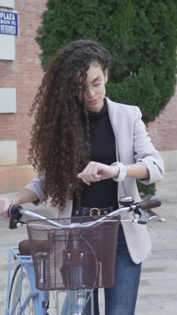 Young Woman Checking Time on Bike