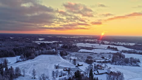 Toma-Panorámica-Aérea-Del-Hermoso-Paisaje-Nevado-De-Invierno-Durante-La-Puesta-De-Sol-Dorada-En-El-Horizonte