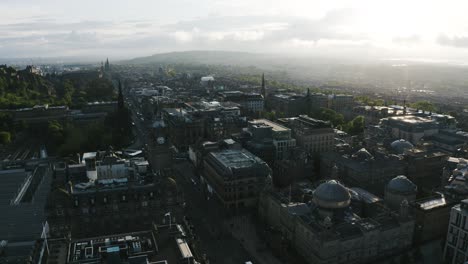 Toma-De-Drones-Del-Centro-De-Edimburgo,-Escocia-Cerca-Del-Atardecer-Con-Una-Torre-De-Reloj-Con-Vista-Al-Vecindario