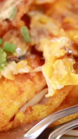 el delicioso pad thai está siendo preparado y servido.