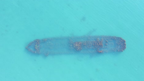 Bootswrack-Auf-Dem-Meeresboden-Im-Flachen-Blauen-Wasser,-Ogano-Britischer-Trawler,-Von-Oben-Nach-Unten