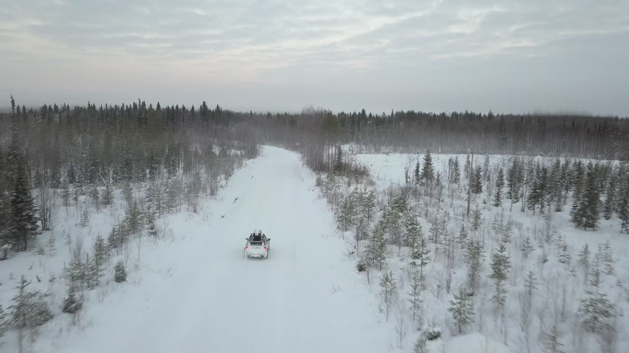 Biler som kjører gjennom et snødekt landskap nær Kuusamo, Finland.