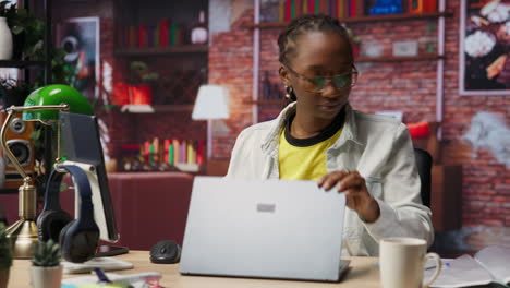 teleworker at home happy to end job shift, closing laptop and leaving desk