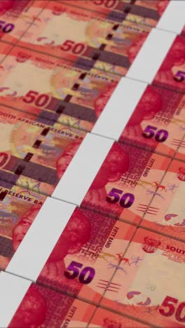 vertical video of 50 south african rand banknotes printed by a money press