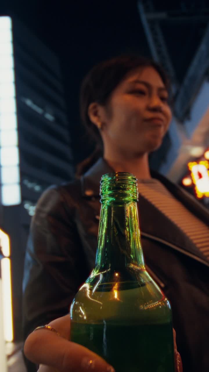 Donna che tiene in mano una bottiglia di soju di notte