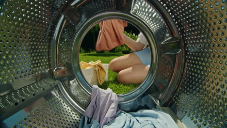 woman loading washing machine in garden