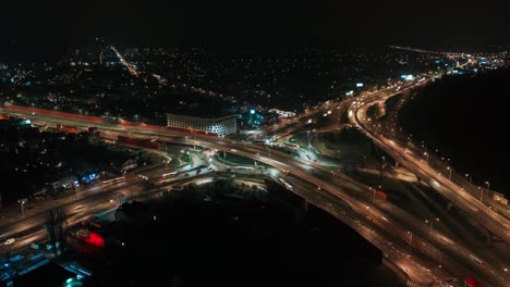 aerial drone time lapse hyperlapse car traffic roundabout circle interchange road at night, top view junction highway intersection in evening. flyover cityscape driving busy junction crossroad