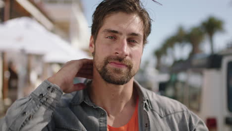 portrait-of-attractive-man-on-beachfront-running-hand-through-hair-feeling-confident