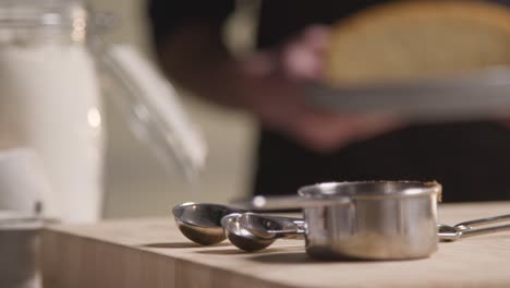 close up of man in kitchen at home putting freshly baked cake onto work surface