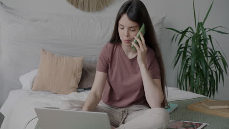 mujer trabajando en una computadora portátil en el dormitorio