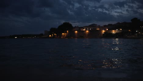 Low-angle-view-of-waves-on-sea-surface-at-coastline-after-sunset