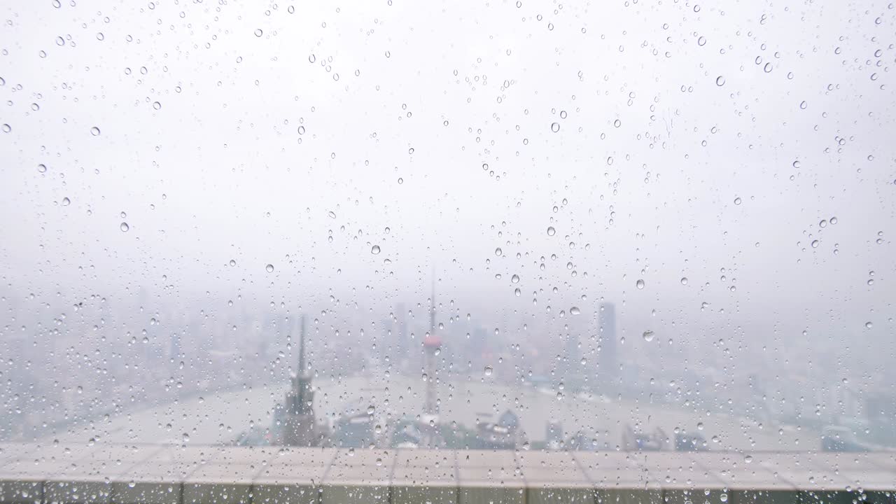 여름에 창문 유리 위에 떨어지는 비 물방울, 느린 동작, 4k 영상, 상하이 의 랜드마크 배경과 함께 강한 비가 떨어집니다.