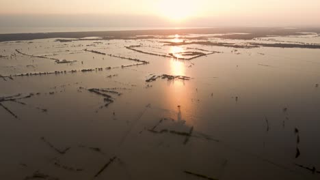 Drones-Aéreos-Vuelan-Sobre-Aviones-Inundados-En-La-Orilla-Del-Lago-Tonle-Sap-Durante-La-Puesta-De-Sol