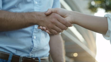 close up footage of manager and assistant shaking hands after important interview