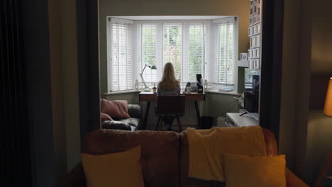 a woman working at a desk in a living room