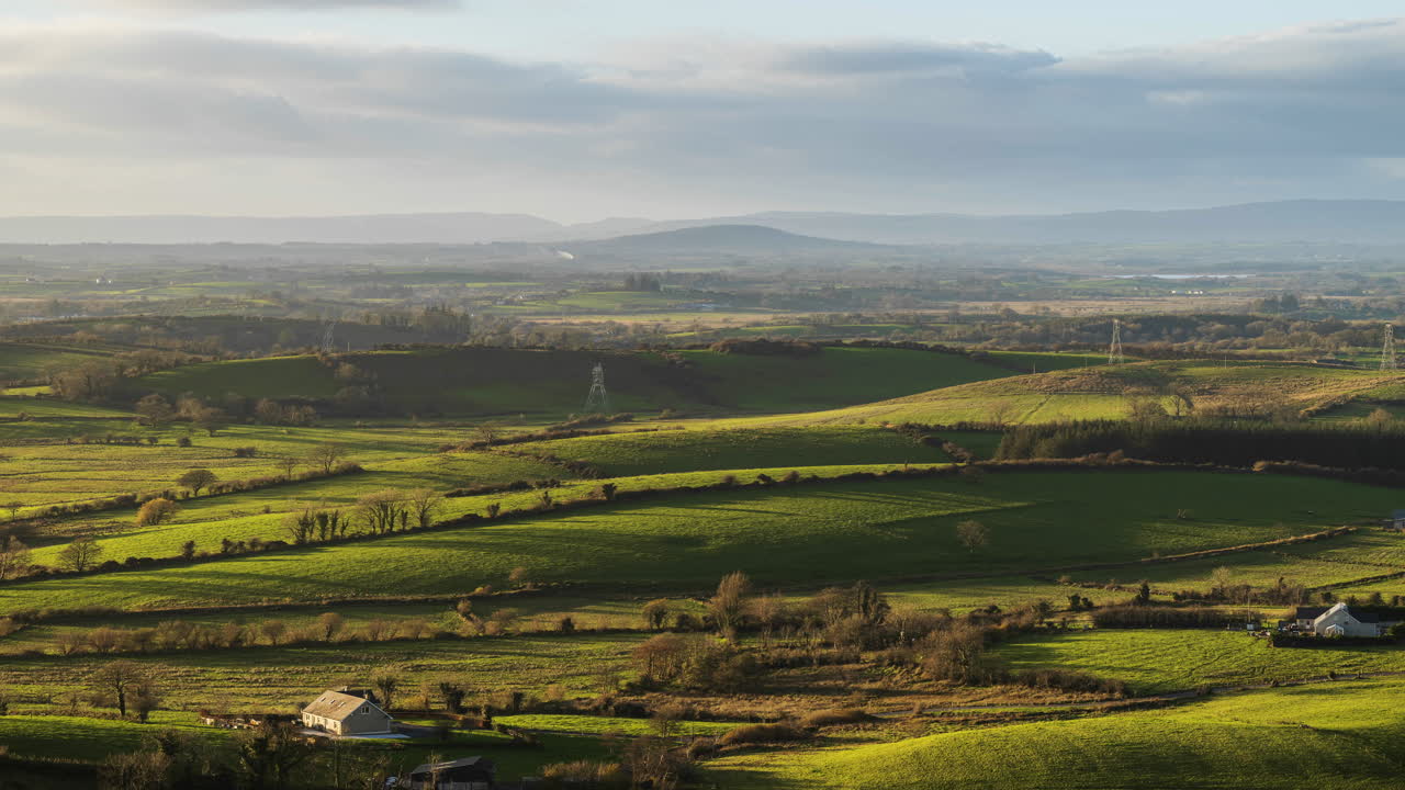 Time lapse of rural farming landscape with grass fields and hills during a cloudy sunny day viewed from Keash caves in county Sligo in Ireland
