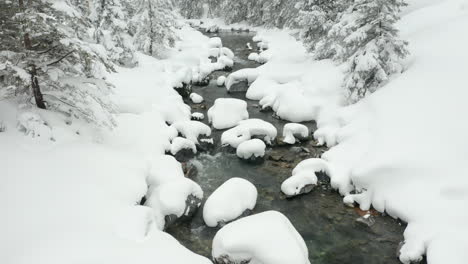 jib down of calm creek in snow covered landscape