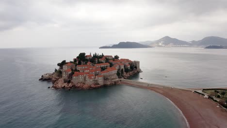 Antena---Sveti-Stefan-Isla-Resort-De-Lujo-En-El-Mar-Adriático,-Montenegro,-Marcha-Atrás