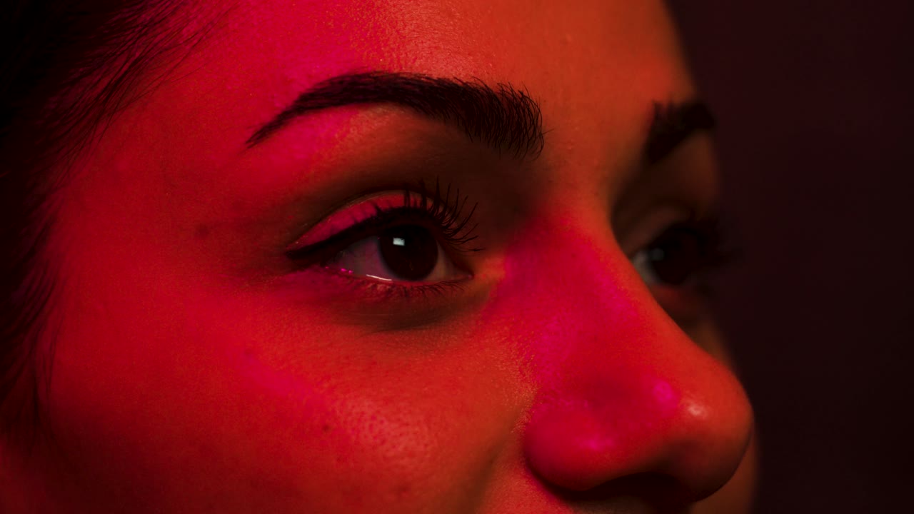 Close up on woman's eyes, she reacts in surprise to a scree