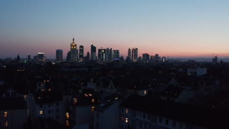 Paisaje-Urbano-Nocturno-Elevado-De-Drones-En-Hora-Azul.-Panorama-Del-Centro-Con-Rascacielos-Contra-El-Cielo-Azul-Rosa-Del-Atardecer.-Fráncfort-Del-Meno,-Alemania