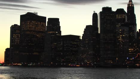 the camera pans from the south tip of manhattan to the lights on the brooklyn bridge at the goldenhour