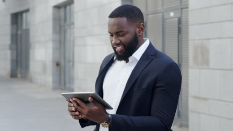 businessman working on pad at city street. professional looking on tablet screen
