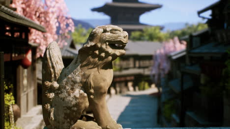 stone lion statue in front of a japanese pagoda