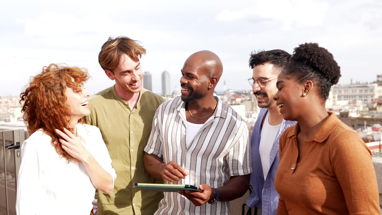 Diverse Group of Friends Laughing and Using Tablet on Rooftop