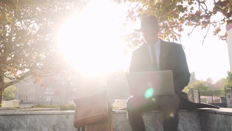 hipster businessman working on his laptop outside counterlight shot