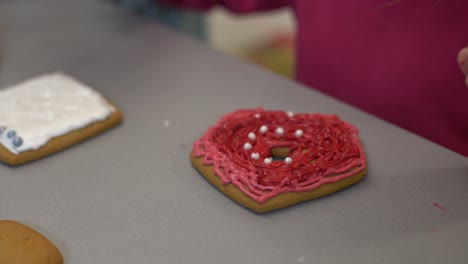 girl decorates homemade gingerbread for easter