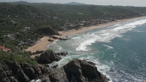 aerial descends to beautiful playa zipolite sand beach in mazunte, mx