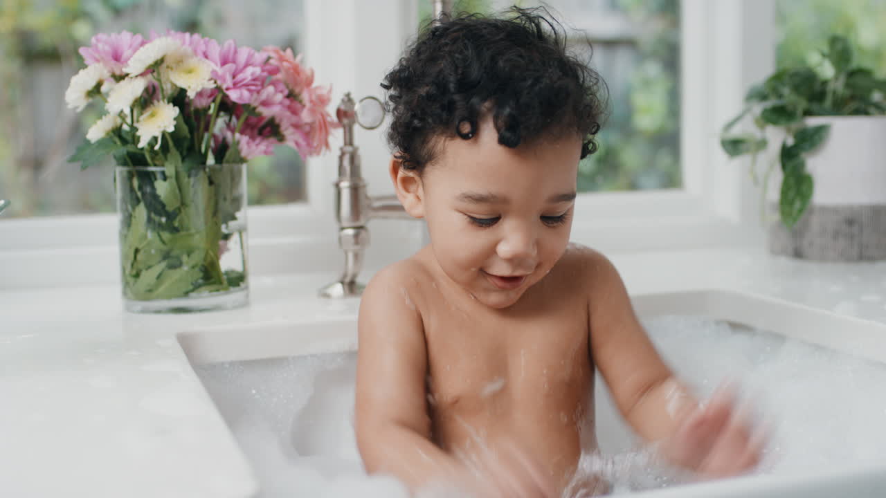 cute baby bathing funny toddler taking bath in kitchen sink having fun with soap bubbles 4k