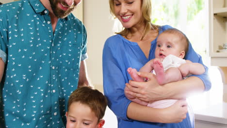 Familia-Sonriente-Mirando-Una-Computadora-Portátil