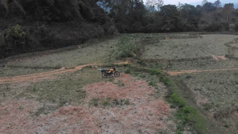 la motocicleta está estacionada en medio de un prado en el campo de laos, aérea