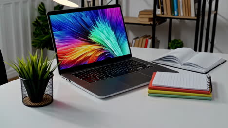 a laptop and notebooks on a clean desk in a modern workspace