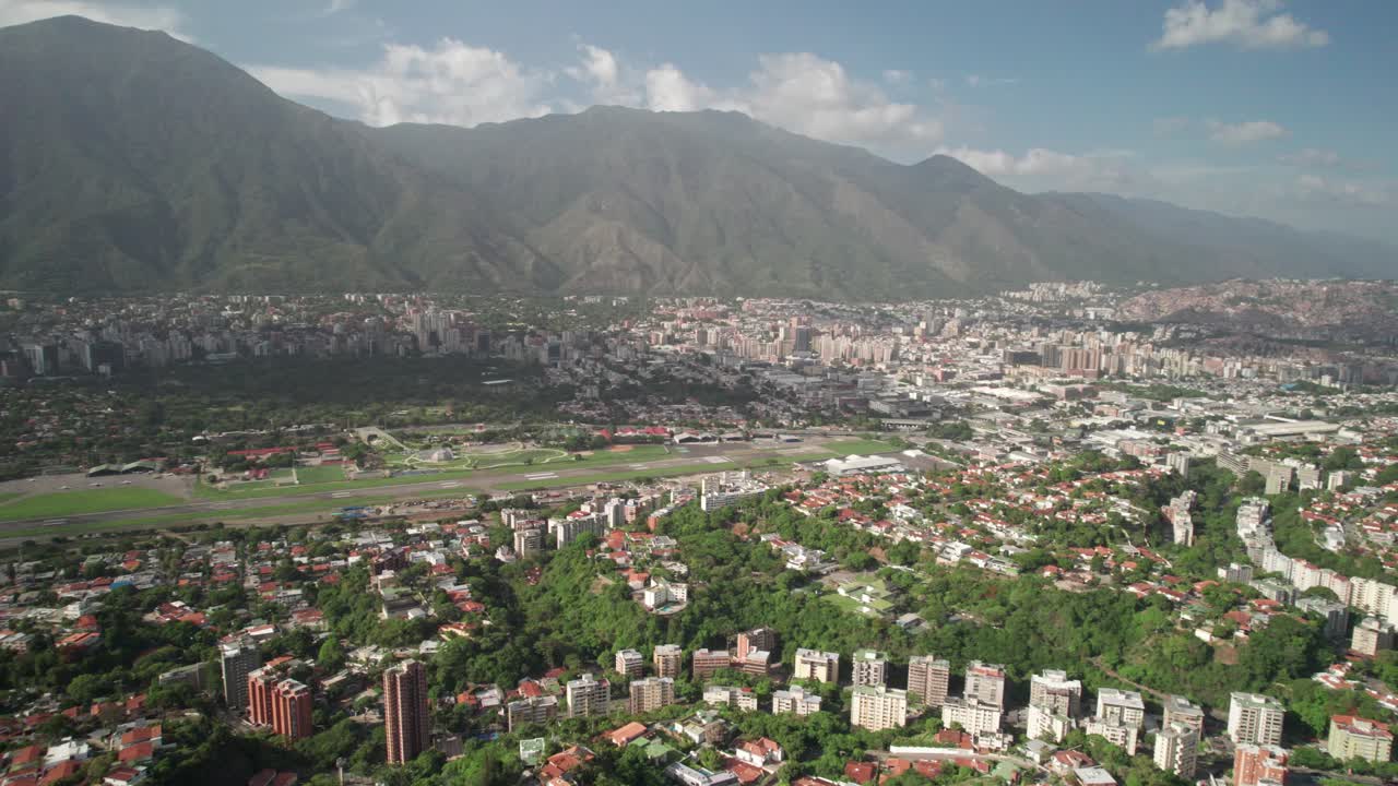 Aerial from Santa Sofía neighborhood showing cityscape and green hill terrain