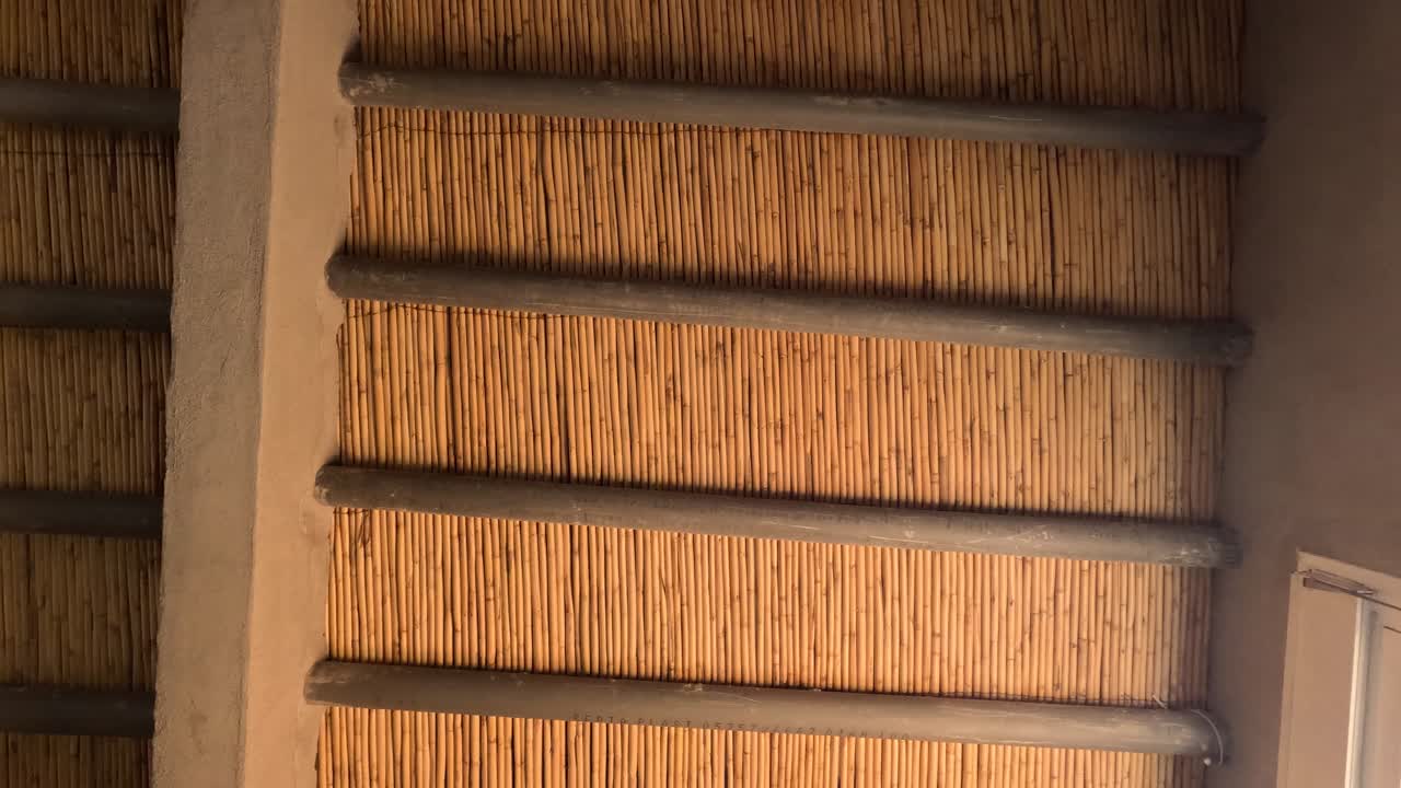 encanto tradicional: explorar la vista interior rústica de las estructuras de techo de caña ordenadamente organizadas en filas dentro de un pintoresco pueblo rural