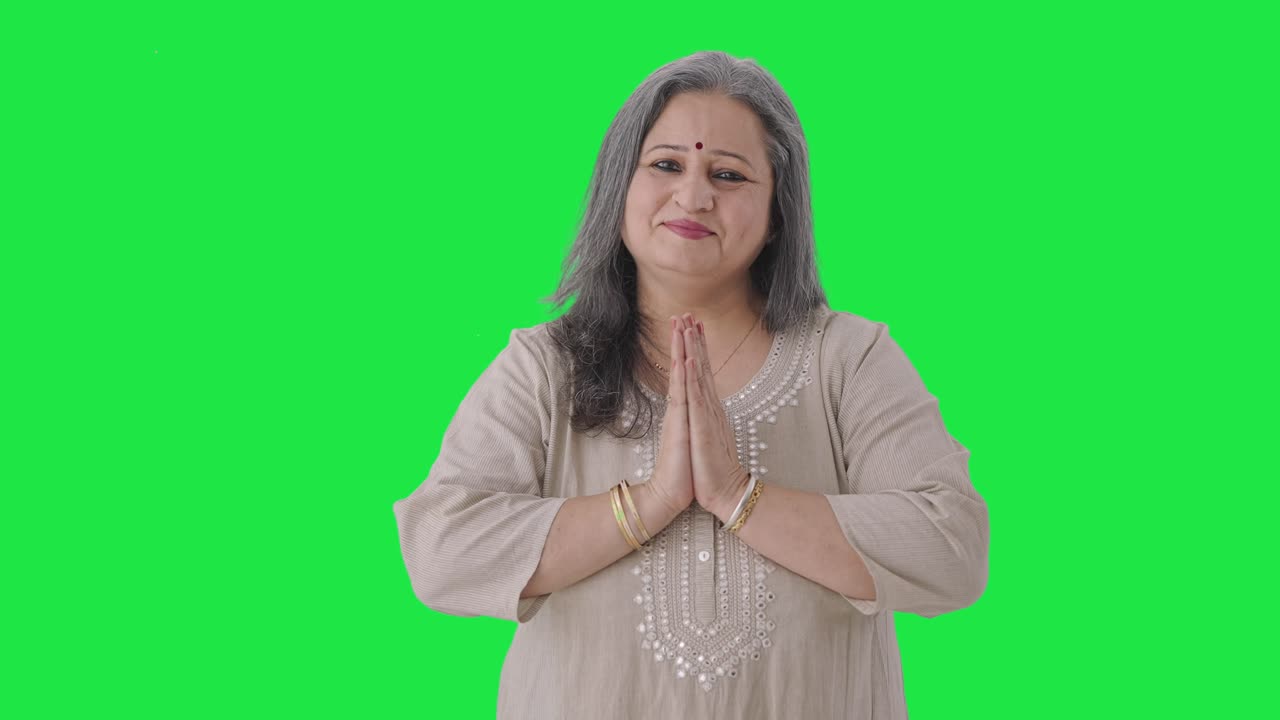 Happy Indian old woman greeting and doing Namaste Green screen