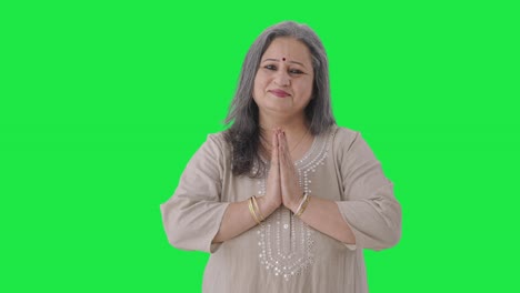 счастливая индийская старуха приветствует и делает namaste зеленый экран