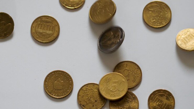 Monete di euro che cadono a terra al rallentatore.