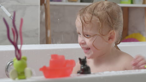 Kleines-Mädchen,-Das-In-Der-Badewanne-Spielt-Und-Wasser-Spritzt